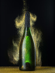 Glitters falling around champagne bottle glowing in the dark. Festive background.