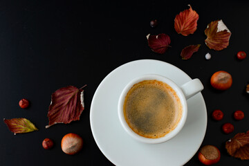 Cup of black coffee hazelnuts autumn fallen leaves on black table background top view Coffee clipart