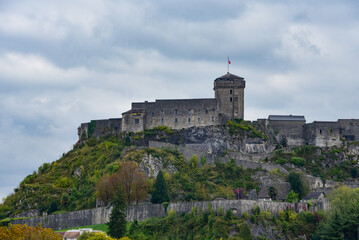 Fototapeta premium Lourdes, France - 9 Oct 2021: The Chateau Fort de Lourdes overlooking the town and Rosary Basilica
