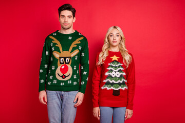 Photo of nice x-mas couple boyfriend girlfriend wear ugly ornament sweater isolated red color background