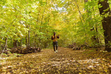 Fototapeta premium African american student walking in the park in autumn season