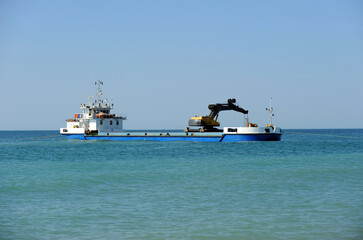 Dragado de arena frente a la playa de Rota en la Costa de Cádiz Andalucía España. Barco dragando en el mar