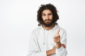 Handsome middle easter man pointing finger at camera with confident look, inviting you, recruiting people, standing over white background