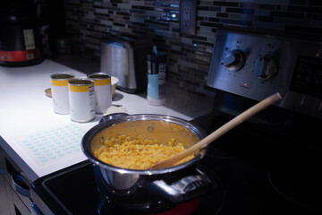 macaroni and cheese in a pot over the kitchen counter. cooking in a kitchen