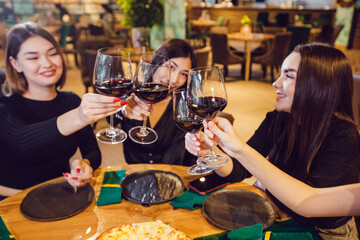 Attractive girls drinking wine at a dinner in a restaurant.