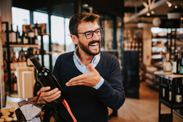 Handsome middle age man buying some healthy food and drink in modern supermarket or grocery store....
