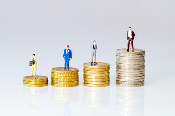 Investment concept. Business toy people standing on stacks of Euro coins. Symbol for increasing or...