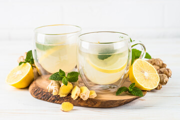 Ginger tea with lemon and mint in glass mug. Healthy hot vitamin drink.