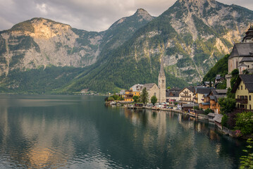 Fototapeta premium Panoramic view of famous old town Hallstatt and alpine deep blue lake in scenic sunset light on a beautiful day in summer, Salzkammergut, Austria