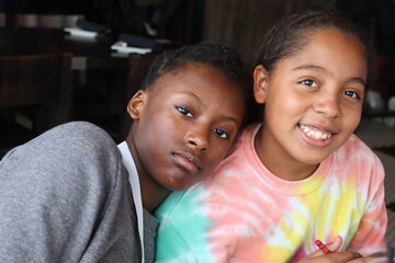 Two African Ameircan Girls sitting indoors close up