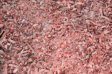wood sawdust. shavings from boards. pink background. grooved surface