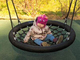 baby swinging on a swing on a sunny autumn day