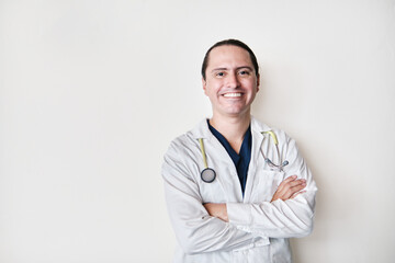 smiling middle-aged latin medical man, crossing his arms on white background with stethoscope