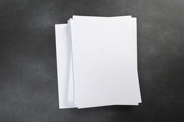 White business card sheet of paper a4 stack on a dark table. Clean portrait A4.