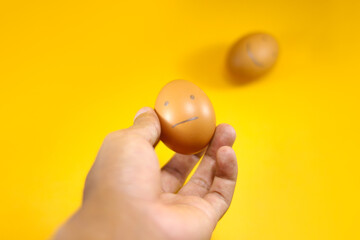 Conceptual Illustration for questionnaire, feedback rating, customer review, experience, and satisfaction survey. Hand choosing sad face brown egg on orange background.