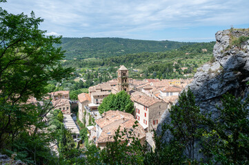 Fototapeta na wymiar View on mountains cliff, old houses, green valley in remote medieval village Moustiers-Sainte-Marie in Provence, France