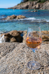Summer time in Provence, glass of cold rose wine on sandy beach and blue sea near Saint-Tropez, Var department, France