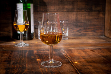 Glasses of strong scotch single malt whisky served on dark wooden table in old pub