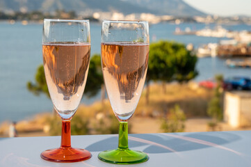 Summer party, drinking of French champagne rose sparkling wine in glasses with view on fishermen harbour of Toulon, France