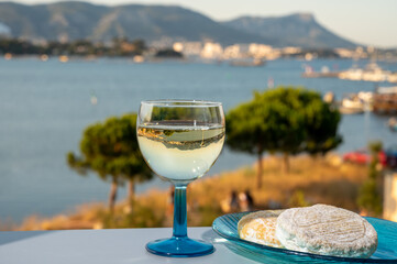 Summer on French Riviera, drinking cold white wine from Cotes de Provence on outdoor terrase with...