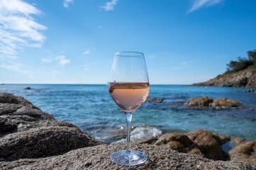 Summer time in Provence, glass of cold rose wine on sandy beach and blue sea near Saint-Tropez, Var department, France