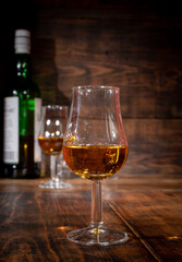 Glasses of strong scotch single malt whisky served on dark wooden table in old pub