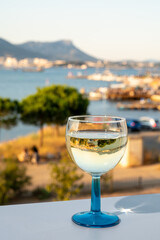 Summer on French Riviera, drinking cold white wine from Cotes de Provence on outdoor terrase with view on harbour of Toulon, Var, France