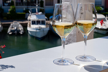 Summer on French Riviera Cote d'Azur, drinking cold dry white wine from Cotes de Provence on outdoor terrase in Port Grimaud, Var, France