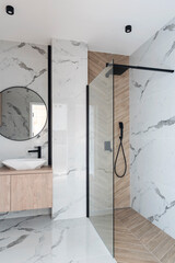 Luxurious bathroom with modern shower with glass and marble on the wall. Interior of room spa with...