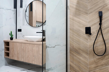 Modern bathroom with stylish shower with glass and ceramic bathroom sink on a wooden cabinet....