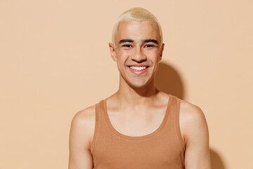 Young smiling happy laughing blond latin american gay man 20s with make up in beige tank shirt...