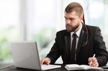 Man using a laptop against office background