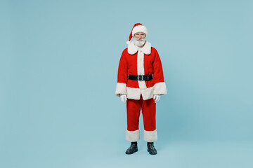 Full body serious old Santa Claus man 50s in Christmas hat red suit clothes posing look camera isolated on plain blue background studio. Happy New Year 2022 celebration merry ho x-mas holiday concept.