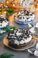 Donuts with chocolate chips on the background of a garland on the Christmas table. Festive table decoration with sweet buns