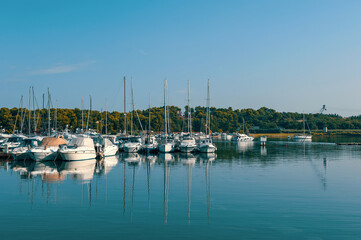 Fototapeta na wymiar Coastline with different sea vessels on a sunny summer day in Vrsar, Croatia