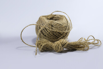 Close-up view of a reel of jute twine or sack rope isolated on a white background.