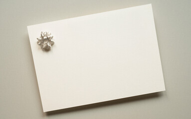 blank white invitation template, rectangle, decorative bow, light background, canvas texture, photo taken from above