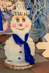 Fototapeta na wymiar Snowman made of wood in city park. Decoration for Christmas and New Years holidays