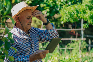 troubled farmer looking at device in field