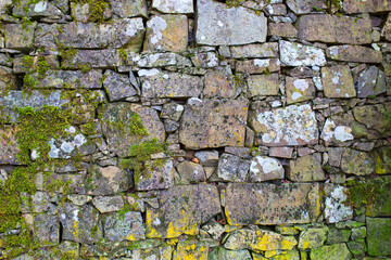 Stone antique old wall as a background or texture. Vintage background of a fortress wall in loft and grunge style with place for text and copy space.