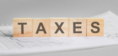 taxes word on wood cube blocks on gray background.