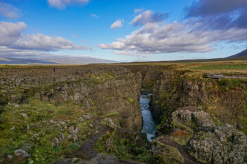 Naklejka premium Bakkavegur, Iceland: Visitors at Kolugljufur Canyon, near the Kolufossar Waterfalls, on the Vididalsa River.