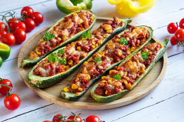 Zucchini stuffed with meat stuffing and corn baked with mozzarella