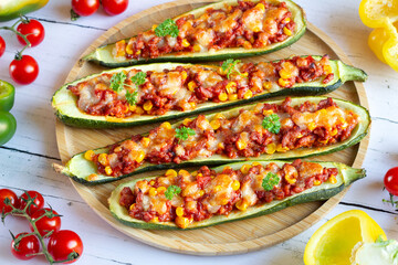 Zucchini stuffed with meat stuffing and corn baked with mozzarella