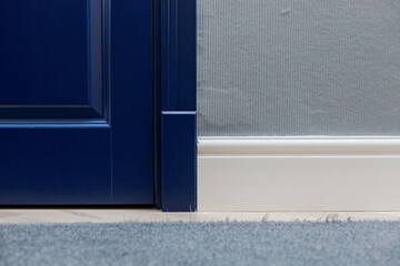 Blue wooden door and adjoining high classic floor plinth. Interior decor elements