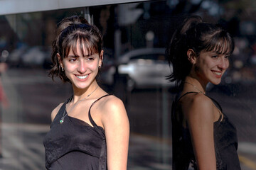 portrait of young woman reflected in a stained-glass window smiling at camera