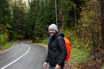 Portrait of  a happy man with orange backpack hiking
