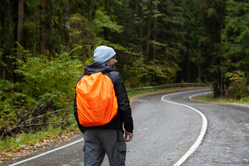 Man with orange backpack hiking