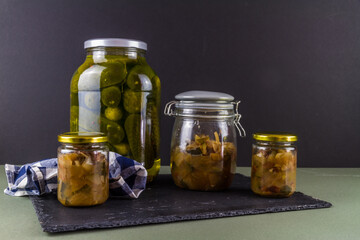 Batch of home made marrow chutney jars and pickled gherkins, landscape, copyspace.