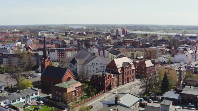 Drone sightseeing flight over Wittenberge in the Prignitz. Many houses and a church can be seen.